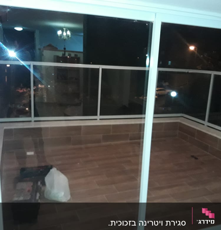 חלונות אלומיניום גדולים במרפסת סגורה בלילה